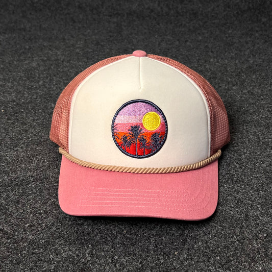 A Trucker Hat with a Sunset And Palm Trees Patch.