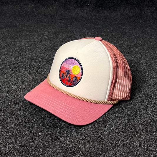 A Trucker Hat with a  Sunset And Palm Trees Patch.