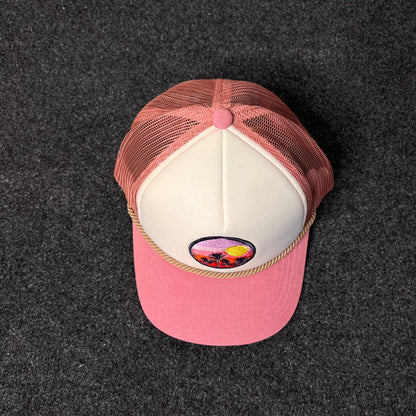 A Trucker Hat with a  Sunset And Palm Trees Patch.