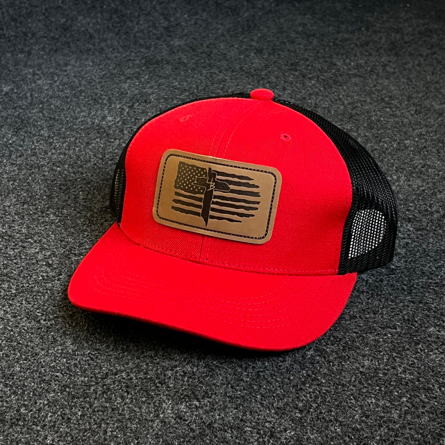 Patriotic Trucker Hat with A Leather Patch featuring A Distressed American Flag and A Knife