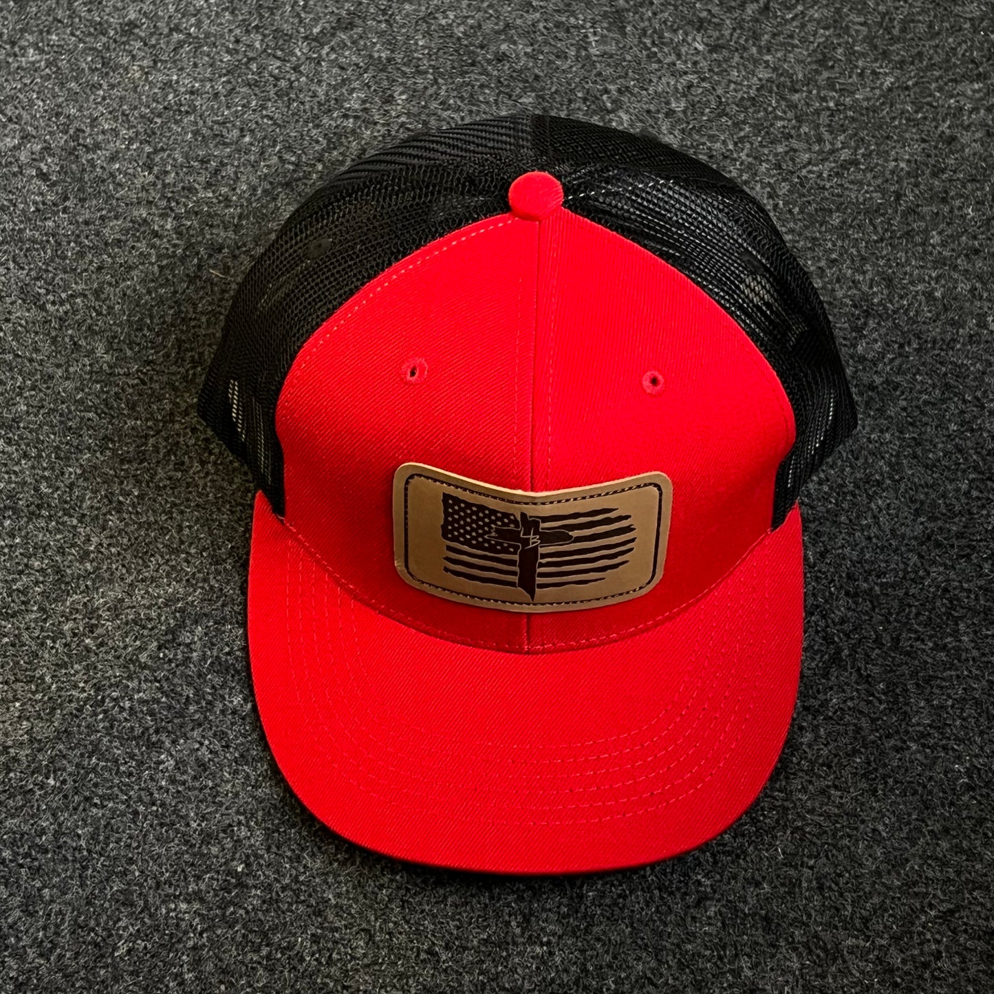 Patriotic Trucker Hat with A Leather Patch featuring A Distressed American Flag and A Knife